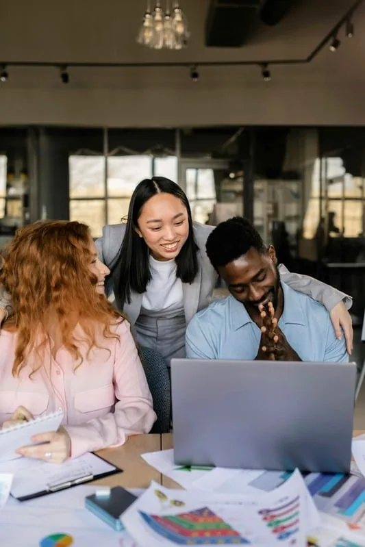 Team collaborating around a laptop